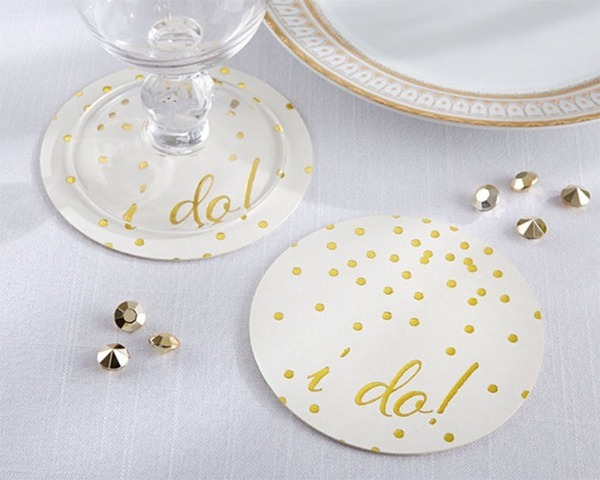 Mẫu lót ly bằng giấy hình tròn màu trắng, đính hạt và chữ màu vàng nổi bật, thường được dùng trong các buổi tiệc sang trọng